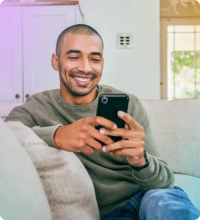 man smiling while using his phone